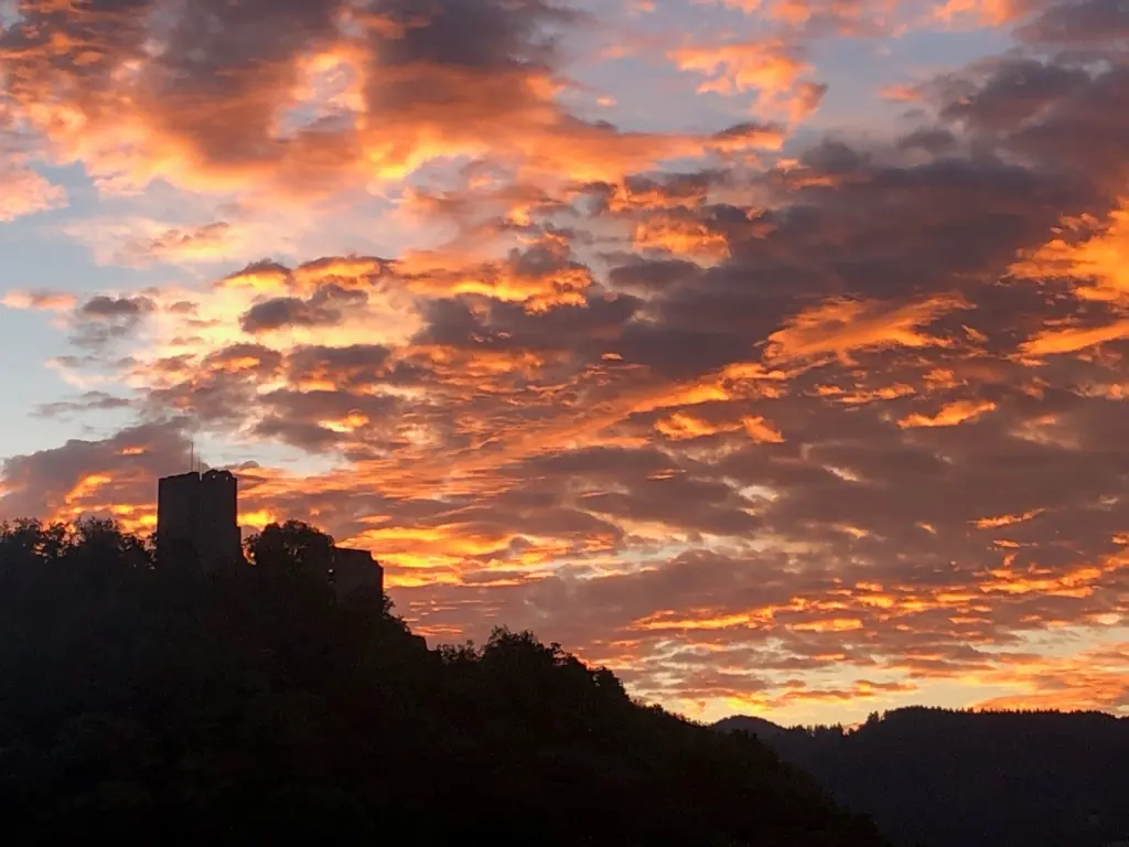 Burgruine vor einem Himmel im Abendro