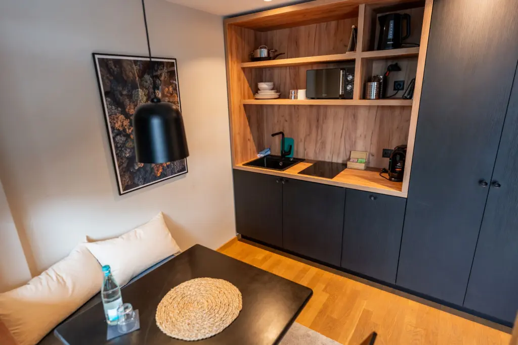 moderne Kuechenzeile mit schwarzen Fronten und Eichenholz mit gemuetlicher Sitzecke