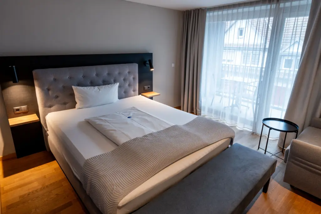 behaglicher Schlafbereich mit Boxspringbett, Kofferbank und Sessel