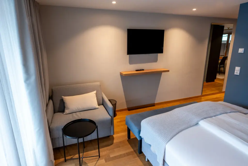 Schlafbereich unserer Apartments mit Blick auf den Sessel und den Fernseher