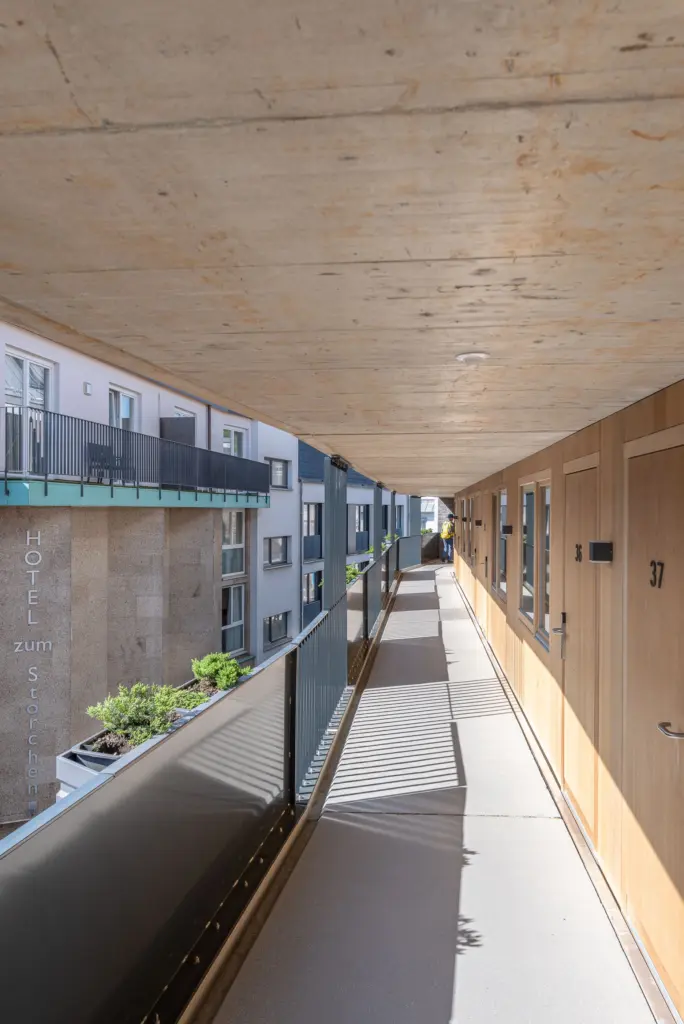 außen liegender Zimmerzugang im 3. Stock mit Blick auf die Korkfassade des Stammhauses