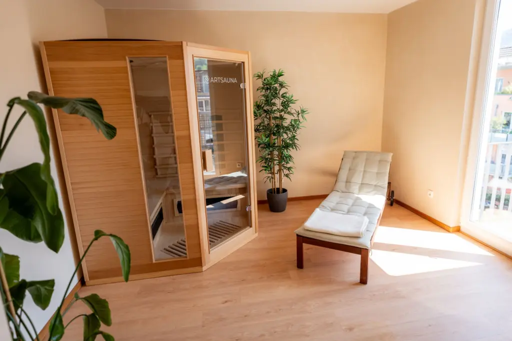 heller Raum mit Infrarotkabine, Liege und Pflanzen