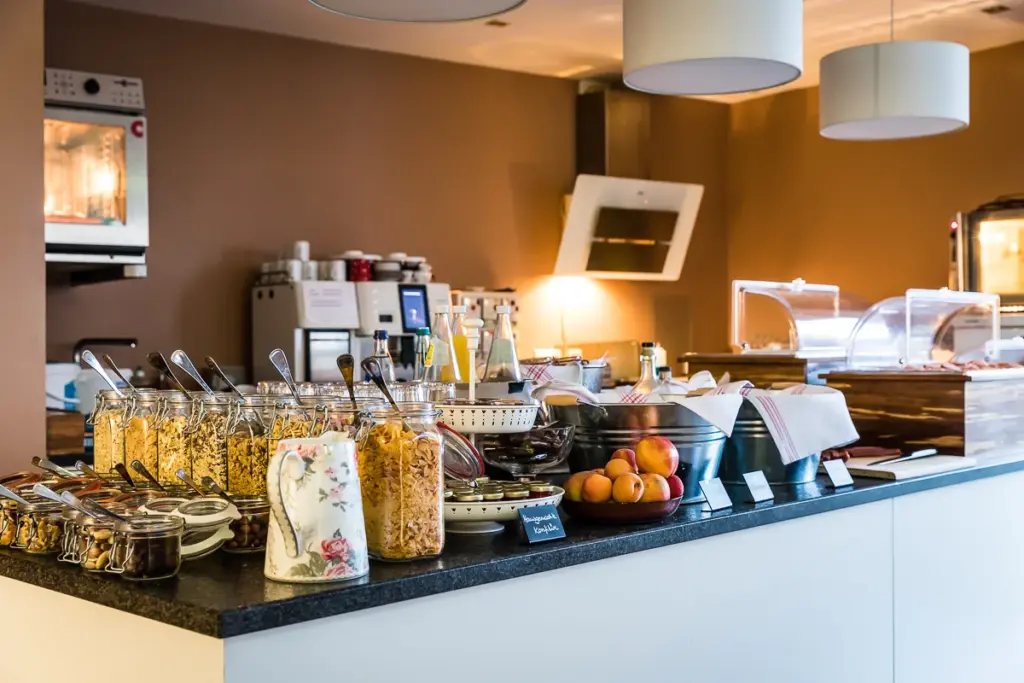 Kuechenblock mit Muesli, Milchkanne, Obst und Saft