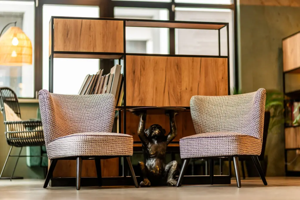 schwarz-weiß gemusterte Sessel neben einem bronze Affentisch