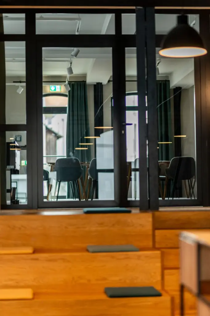 große Sitztreppe aus Eichenholz dahinter eine Glasfront mit Blick in den Tagungsraum