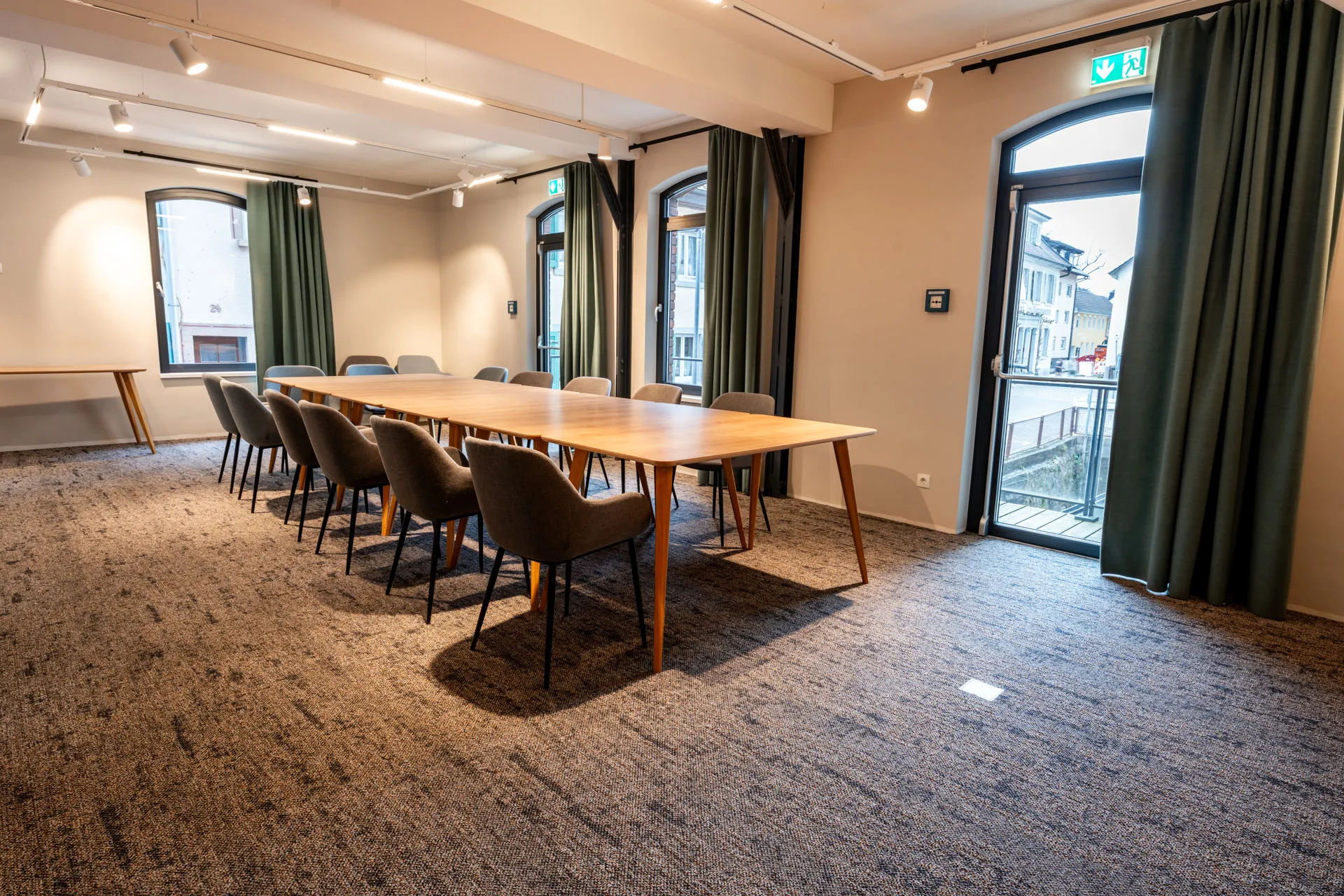 modern eingerichteter, heller Tagungsraum mit bodentiefen Fenstern und Blockbestuhlung
